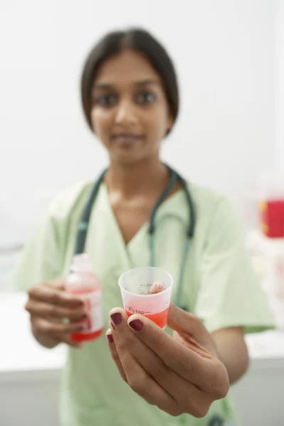 Médico que sostiene la medicina en la medida líquida — Foto de Stock