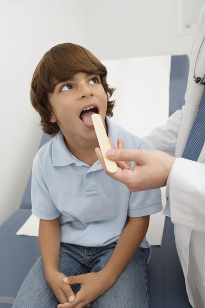 Undersöka pojkens hals med tungspatel — Stockfoto