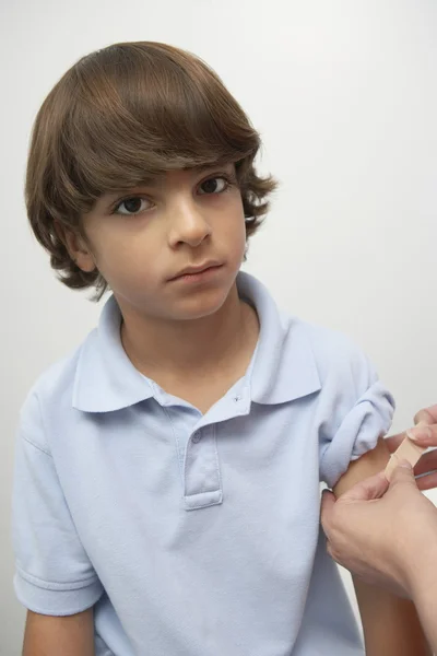 Hands Applying Bandage On Boy 's Arm — стоковое фото