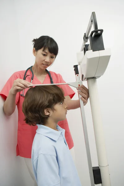 Doktor çocuğu yüksekliğini ölçme — Stok fotoğraf