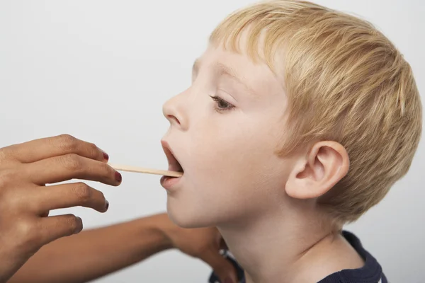 Manos examinando la garganta del paciente — Foto de Stock