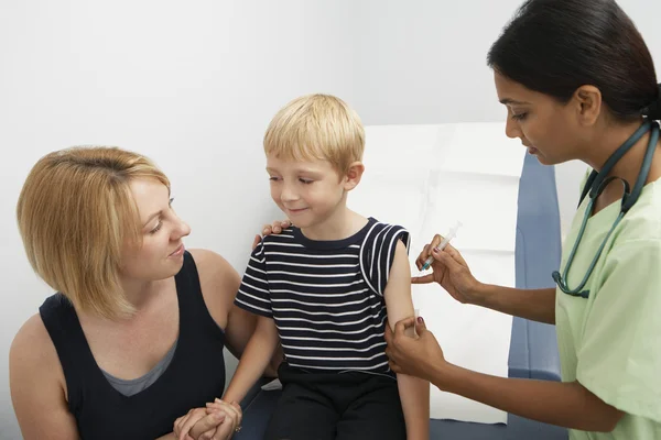 Madre che sostiene il figlio che riceve l'iniezione — Foto Stock