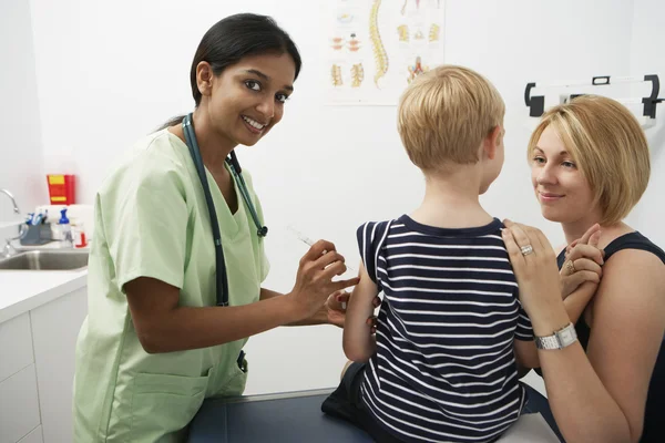 Mère supportant garçon recevant l'injection — Photo