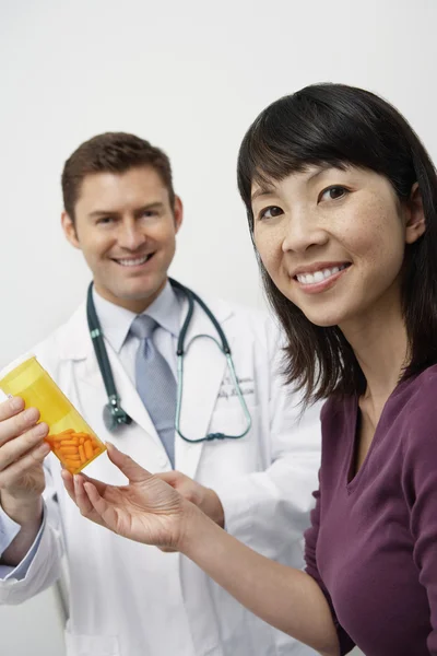 Médecin et patient tenant bouteille de médicament — Photo