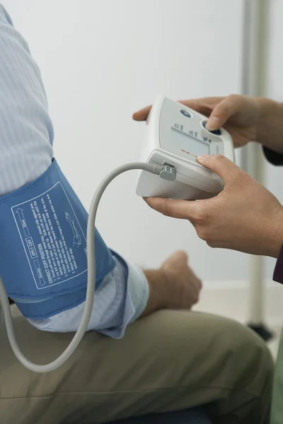 Fechar de Médico Verificando a Pressão Arterial do Paciente — Fotografia de Stock