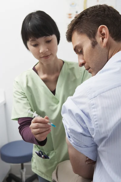 Medico iniettando paziente — Foto Stock