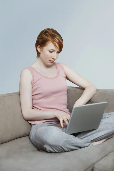 Evde dizüstü bilgisayar kullanan bir kadın — Stok fotoğraf