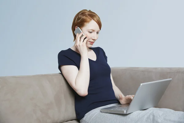 Kvinna på samtal när du använder laptop — Stockfoto
