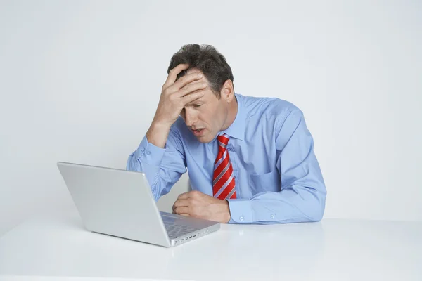 Депрессивный бизнесмен смотрит на ноутбук — стоковое фото