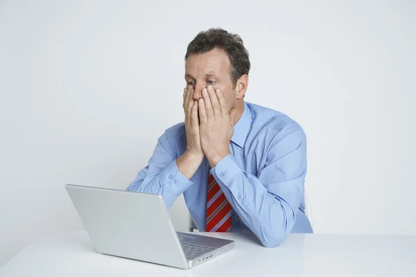 Depressiver Geschäftsmann blickt auf Laptop-Bildschirm — Stockfoto