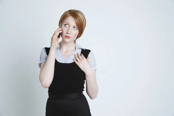 Vrouw zoekt omhoog tijdens het gebruik van mobiele telefoon — Stockfoto