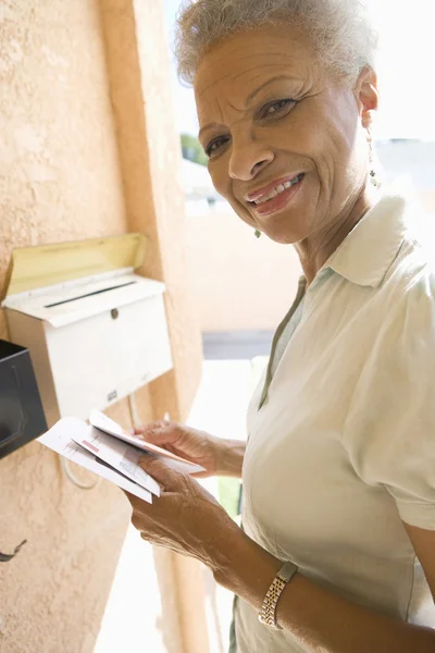 Äldre kvinna samla brev från postlådan — Stockfoto