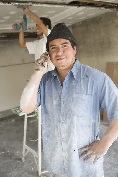 Hispanic construction worker with mobile — Stock Photo, Image