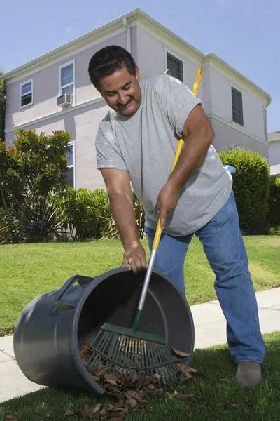 Homem raking folhas no jardim — Fotografia de Stock