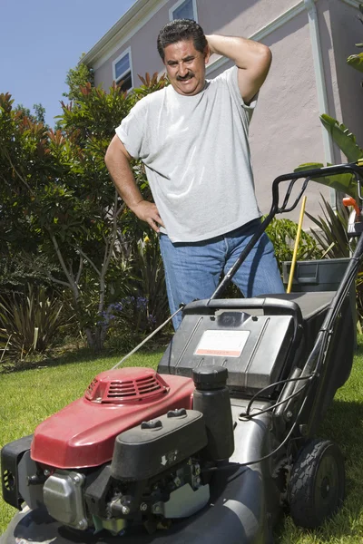 Homem olhando para cortador de grama — Fotografia de Stock