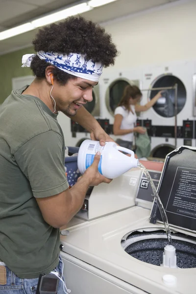 Счастливый молодой человек возле стиральной машины — стоковое фото