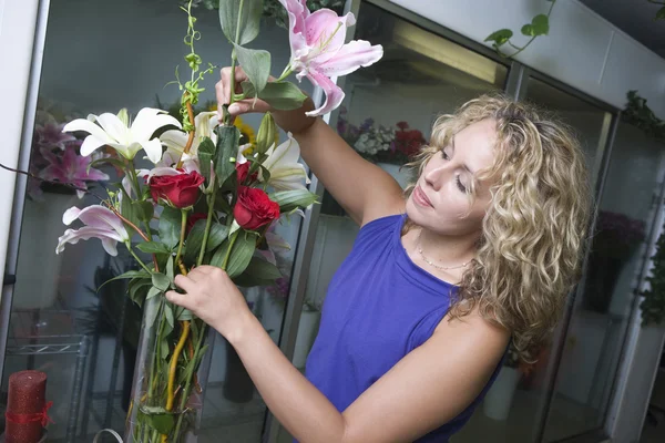 Blumenhändler arrangiert Blumen in Vase — Stockfoto