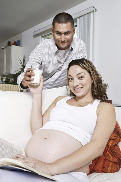 Homme donnant un verre de lait à une femme enceinte — Photo
