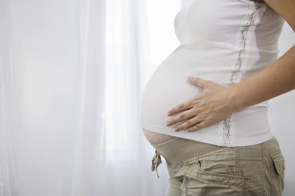 Zwangere vrouw raakt haar buik aan — Stockfoto