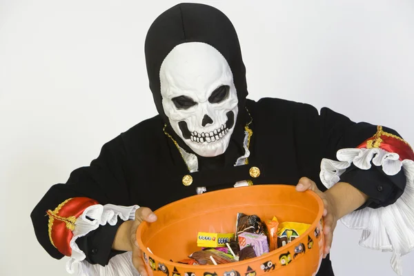 Pojken håller skål med godis i halloween outfit — Stockfoto