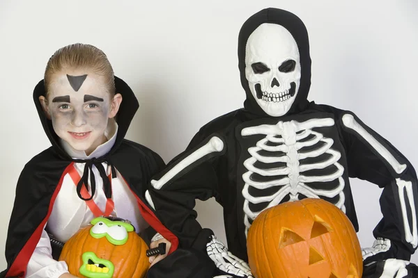 Dos chicos vestidos con disfraces de Halloween sosteniendo Jack-O-Lanterns —  Fotos de Stock