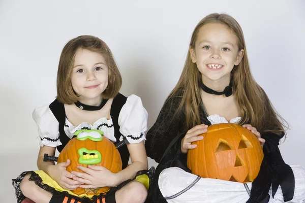 Dos chicas vestidas con disfraces de Halloween sosteniendo Jack-O-Linternas — Foto de Stock