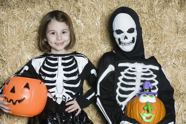 Niños con disfraces de esqueleto sosteniendo Jack-O-Linternas — Foto de Stock