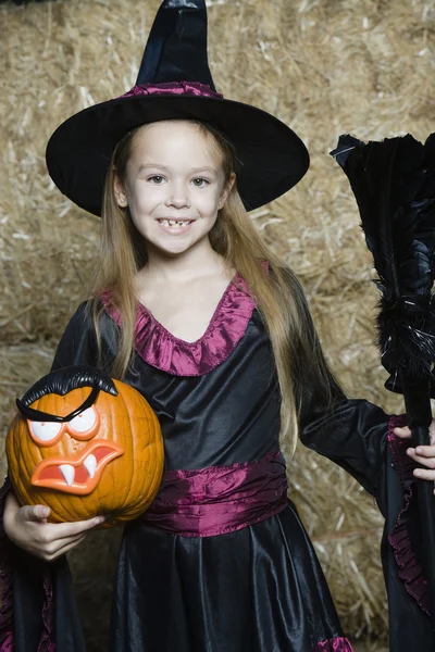 Meisje in halloween outfit houdt hefboom-o-lantaarn en bezemsteel — Stockfoto