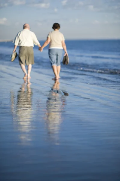 Casal sênior caminhando juntos na praia — Fotografia de Stock