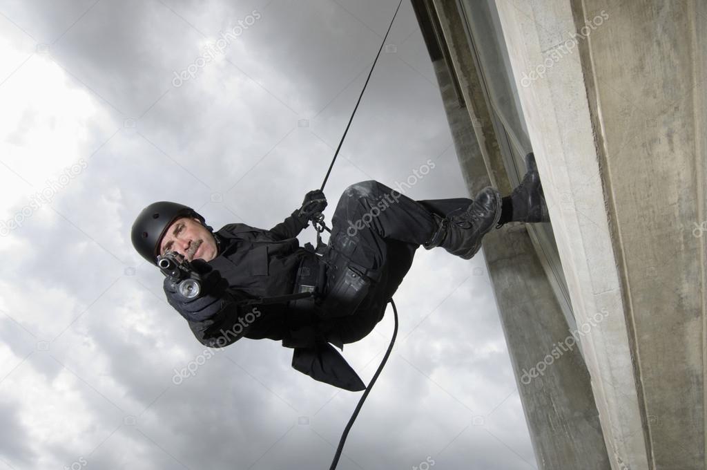 SWAT Team Officer Aiming Gun While Rappelling