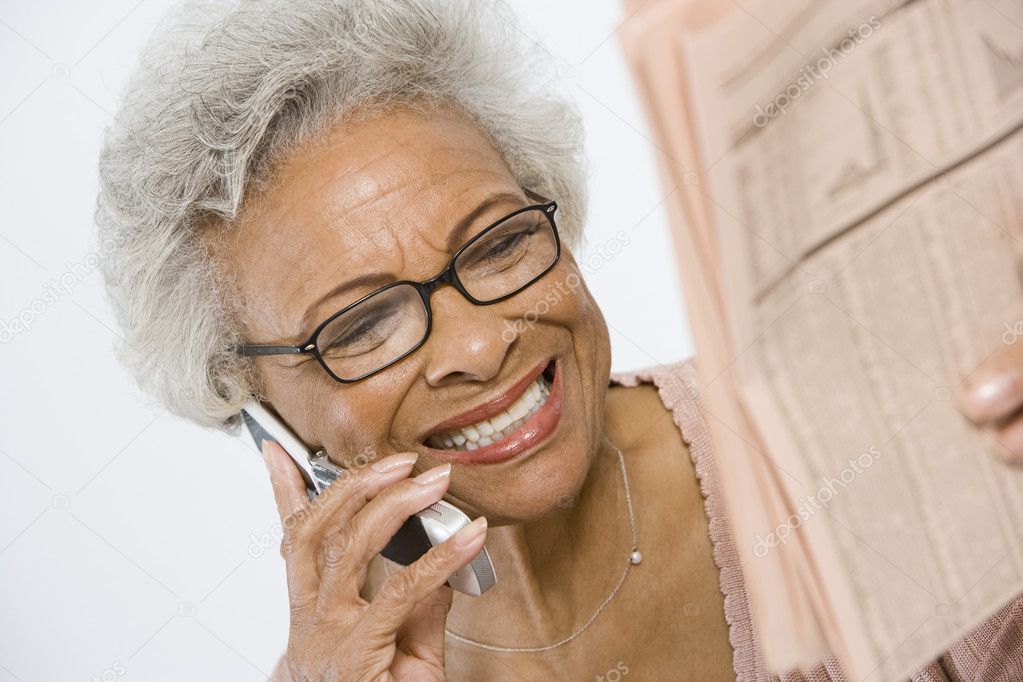 Cheerful Senior Woman Studying Stocks And Shares In Newspaper