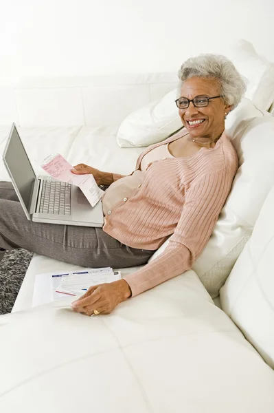 Fröhliche Seniorin nutzt Laptop zu Hause — Stockfoto