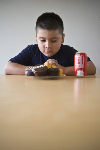 Pojken tittar på dessert på bord — Stockfoto