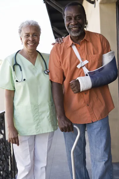 Paciente com deficiência em pé com o médico — Fotografia de Stock