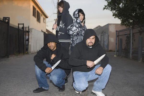 Quatro ladrões agressivos segurando facas — Fotografia de Stock