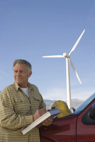 Старший человек работает на ветряной ферме — стоковое фото