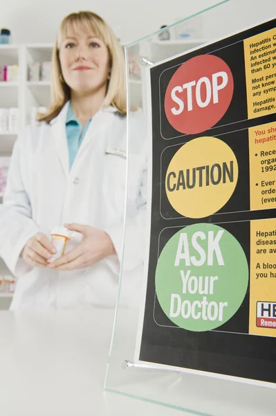 Farmacêutico em pé perto de tabuleta — Fotografia de Stock