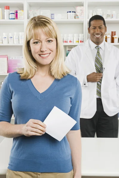 Mujer recogiendo medicamentos recetados en farmacia — Foto de Stock