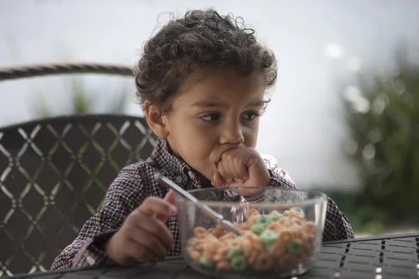 Fundersam liten pojke med spannmål skål — Stockfoto
