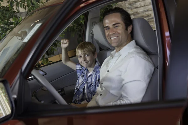 Cheerful boy sitting in car with his father — Stock Photo, Image