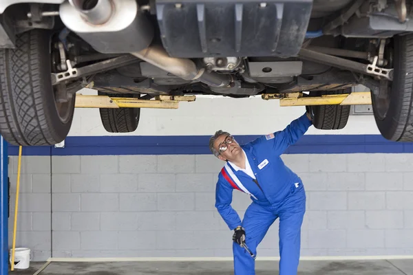 Mechaniker überprüft Auto in Kfz-Werkstatt — Stockfoto