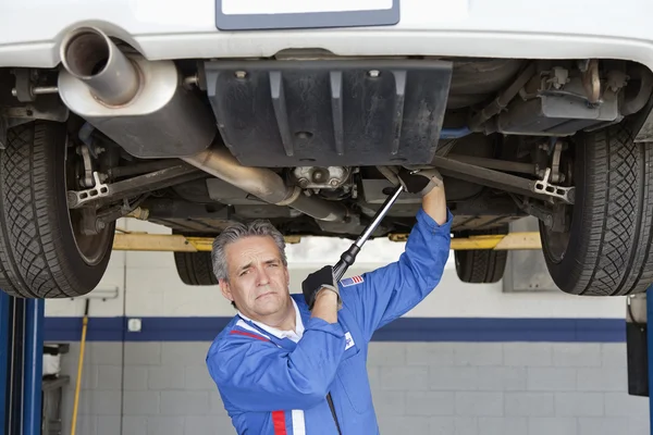 Portrait of mechanic working under car — Stock Photo, Image