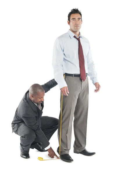 Tailor taking measure leg of customer — Stock Photo, Image