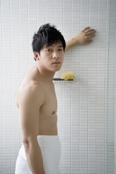 Portret van een jongeman in een handdoek gewikkeld — Stockfoto