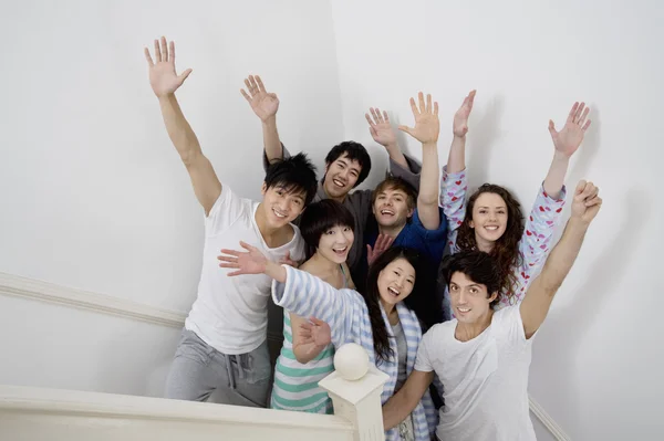 Group of young friends raising arms — Stock Photo, Image