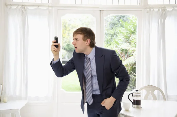 Überraschter Geschäftsmann schaut auf sein Handy — Stockfoto