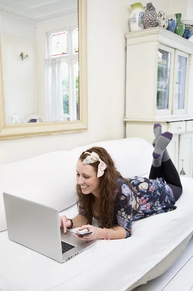 Frau benutzt Laptop auf Sofa — Stockfoto