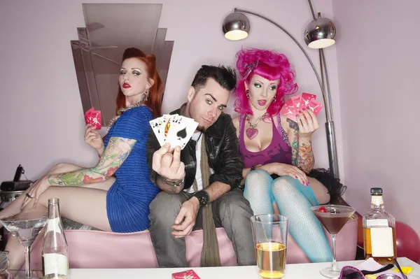 Man showing playing cards tattooed sexy women sitting besides — Stock Photo, Image