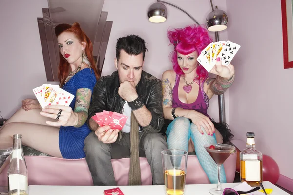 Portrait of females showing their playing cards while man thinking — Stock Photo, Image