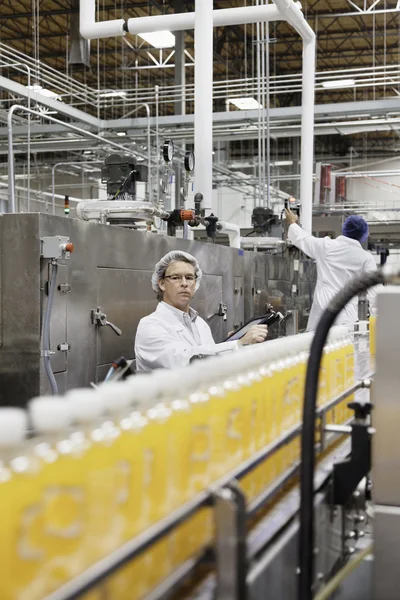 Hombres que trabajan en una planta embotelladora —  Fotos de Stock